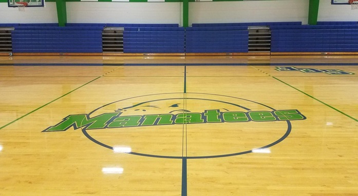 Empty SCF gym center court with MANATEES painted on floor.
