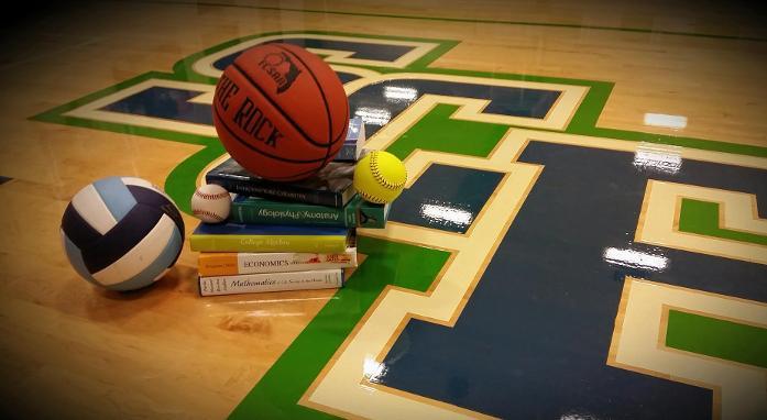 stack of books and sports balls on the gym floor with SCF logo underneath